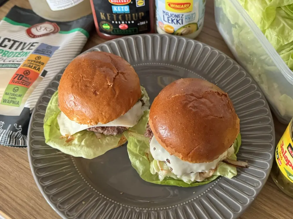 Dwa domowe burgery z sałatą na talerzu, fast food w wersji z kontrolą kalorii